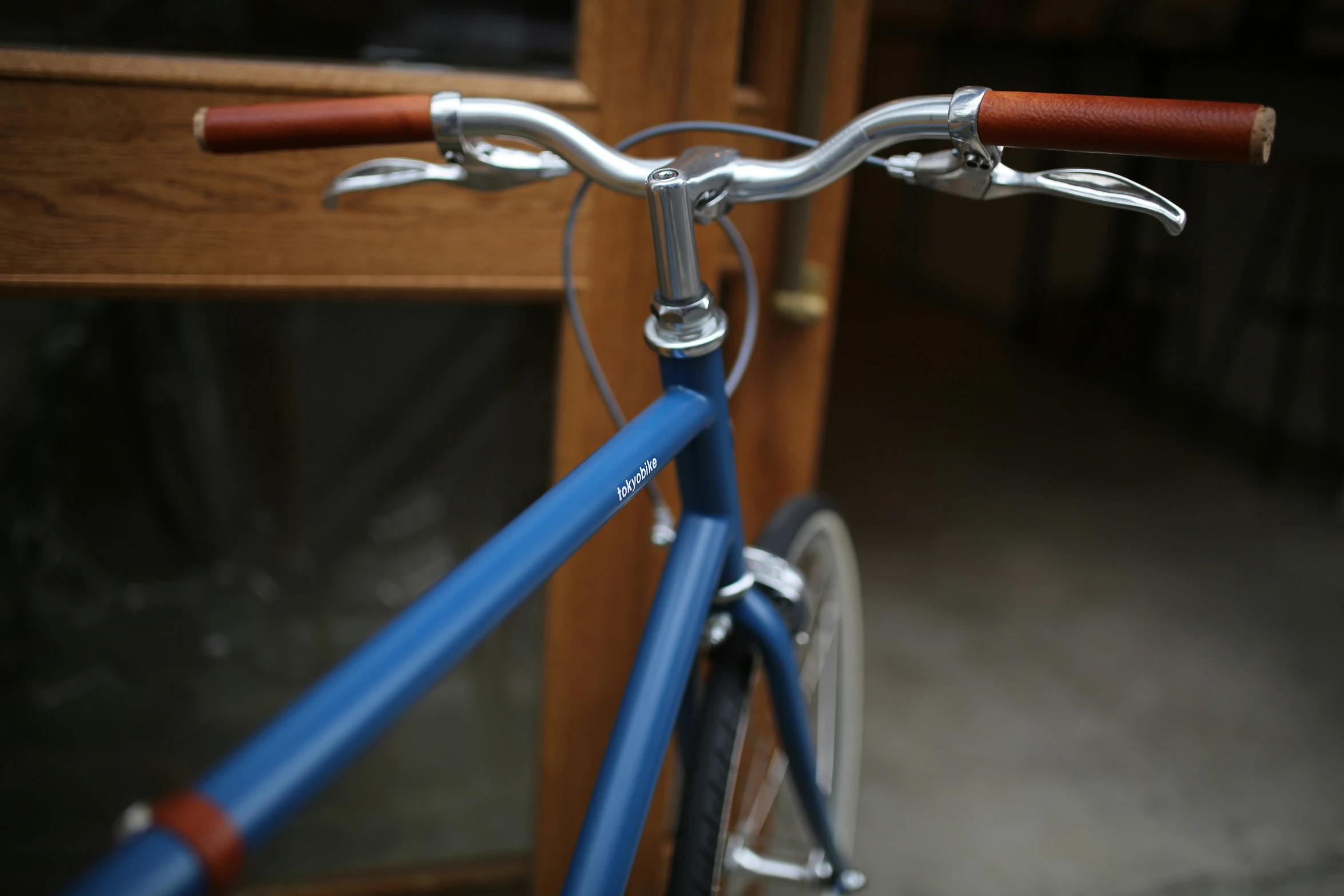 a blue bicycle parked by a wooden door