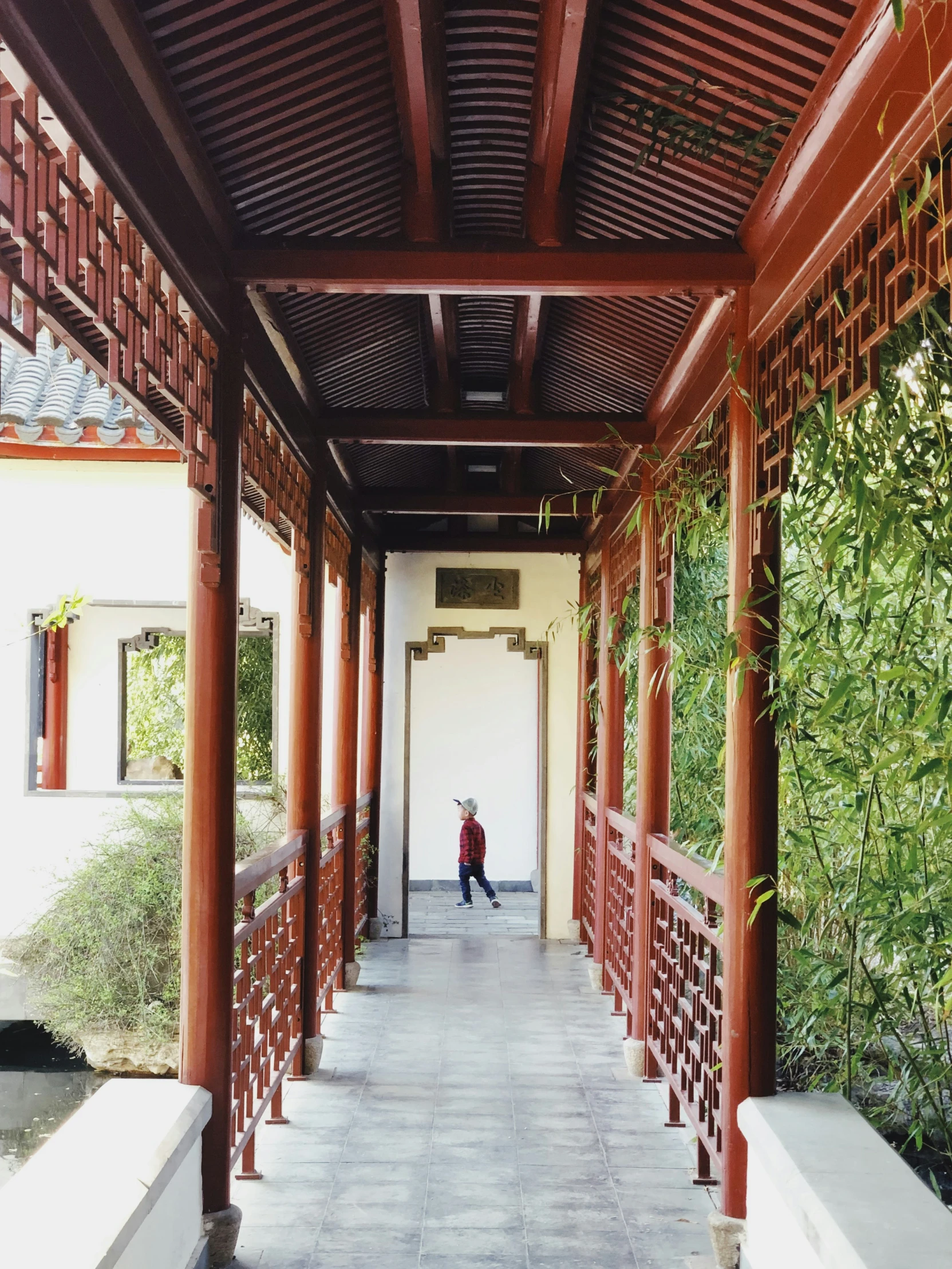 a person standing under a red wooden ceiling