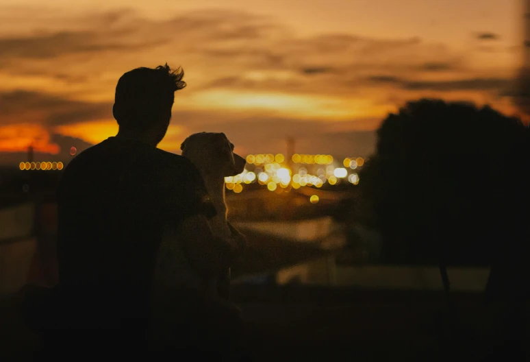 two men on top of a building watching the sun set