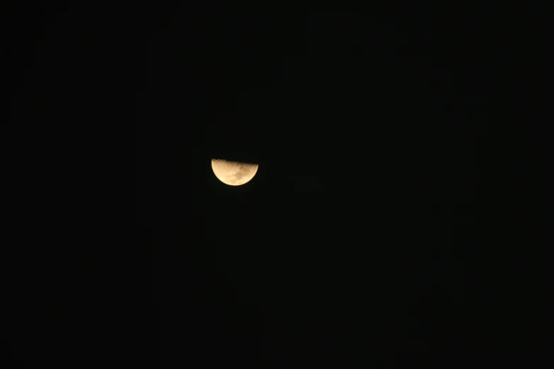 there is a partial moon taken through the night sky