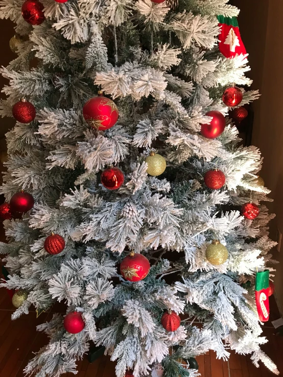 a white tree covered in multi colored ornaments