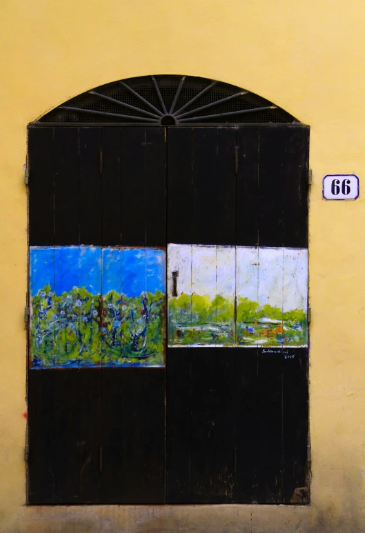 a painting on the side of a door shows a scenic countryside