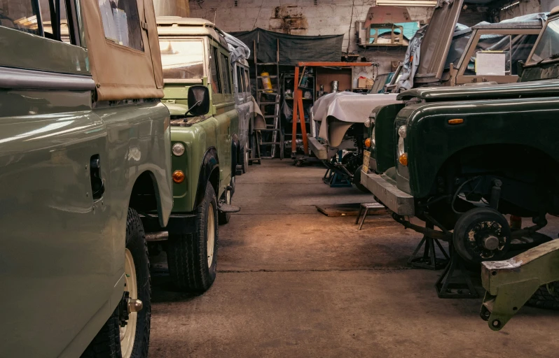green army vehicles are lined up in a warehouse
