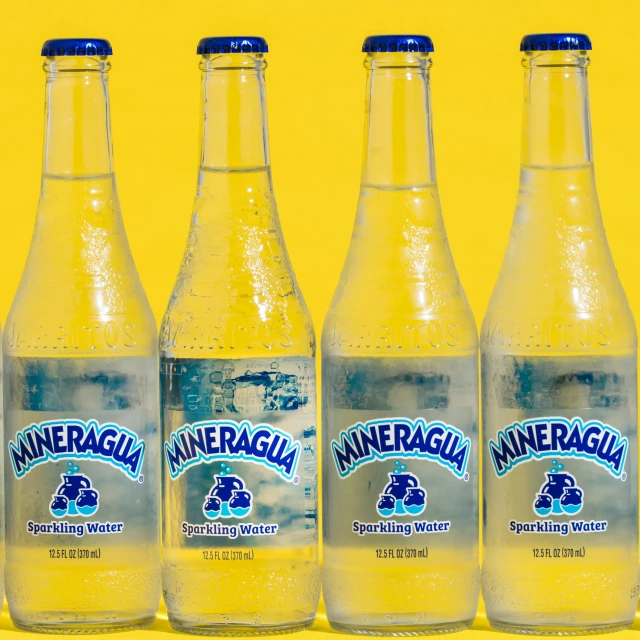 three bottles of mineral water on yellow background