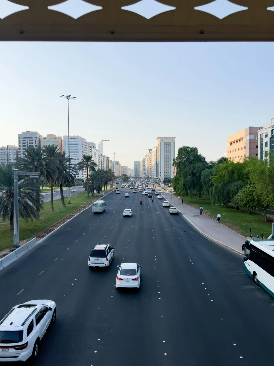 traffic travelling on two lanes in a city with tall buildings