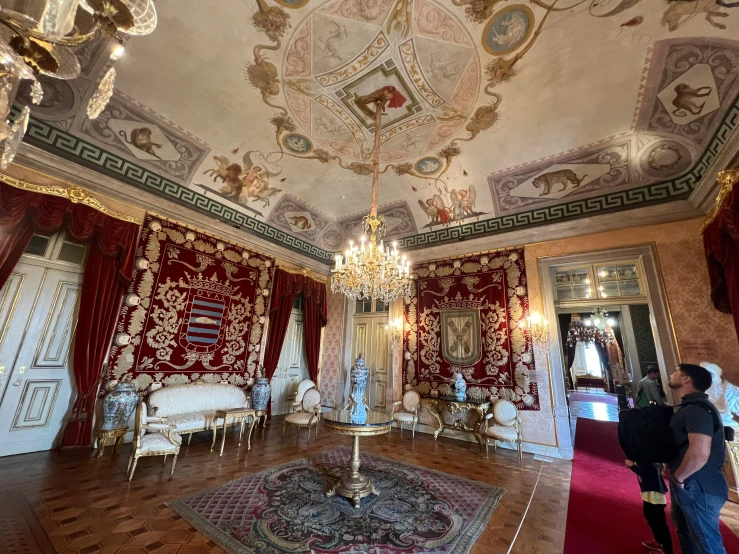 the large room has ornate decor, chairs, and mirrors