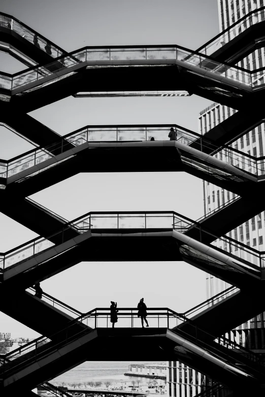 a man walking across a bridge above a river