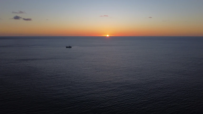 a boat traveling on the ocean during sunset