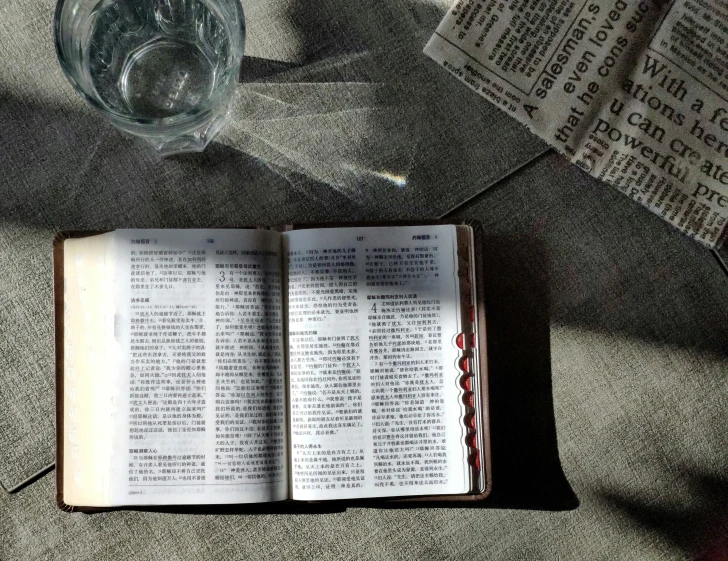 a close up of a book near a cup and cup