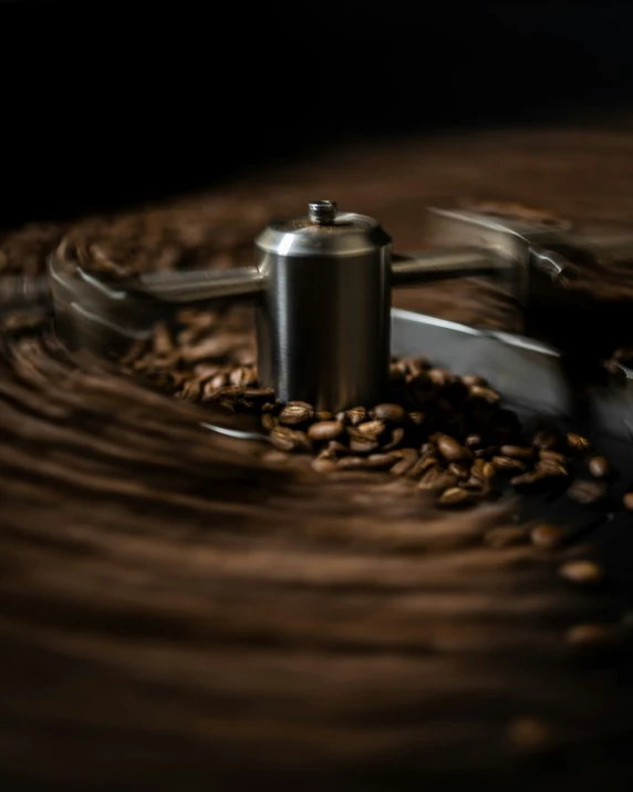 some coffee is on a wood table with a grinder