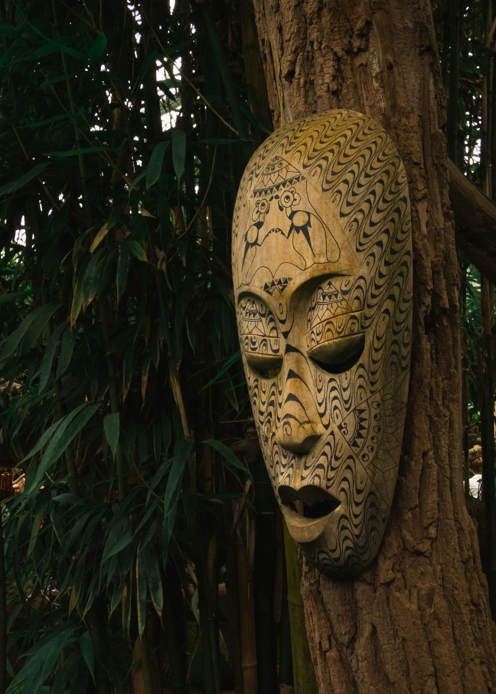 the large statue is placed in front of a tree