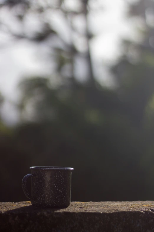 there is a black coffee cup sitting on the ledge