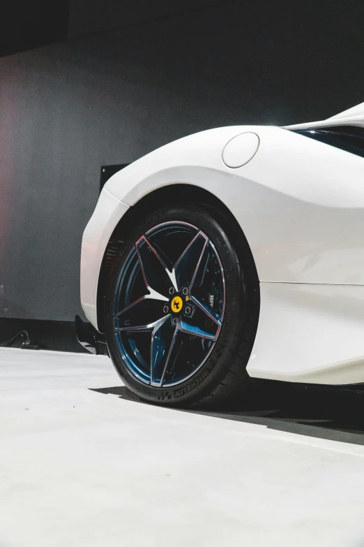 a white sports car with yellow detailing sits in a parking garage