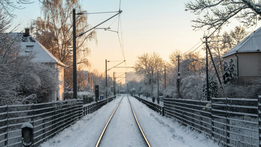 the train tracks run along a snowy path