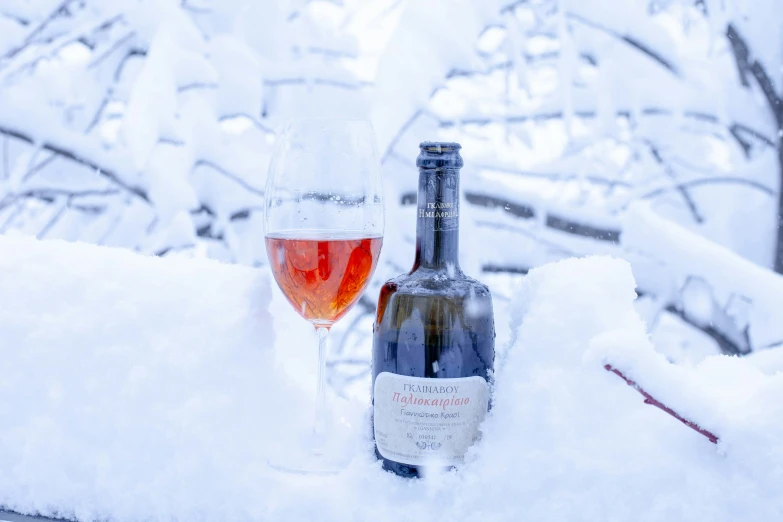 two bottles in the snow with a glass