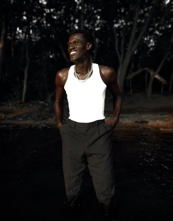 a young man smiling in front of a forest