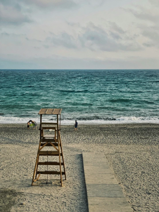 a lifeguard seat on the side of a sandy beach