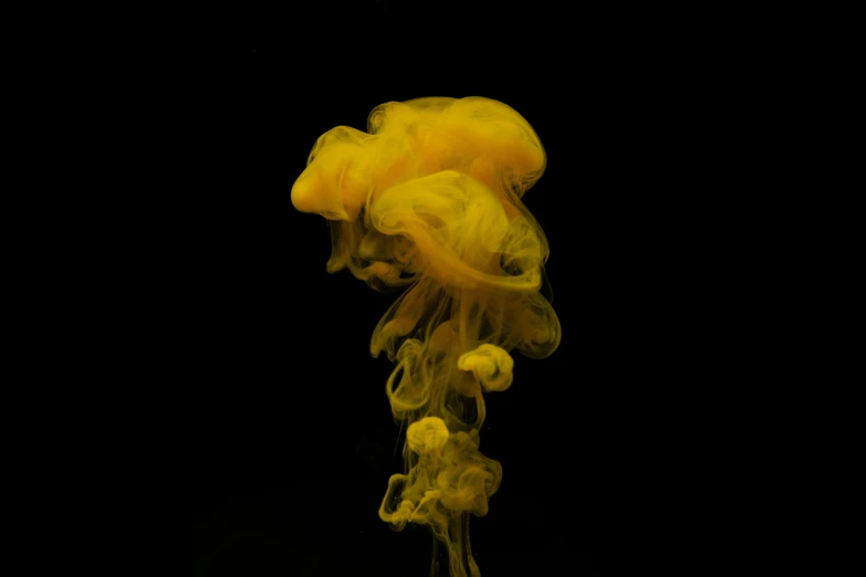 yellow ink floating in a black water