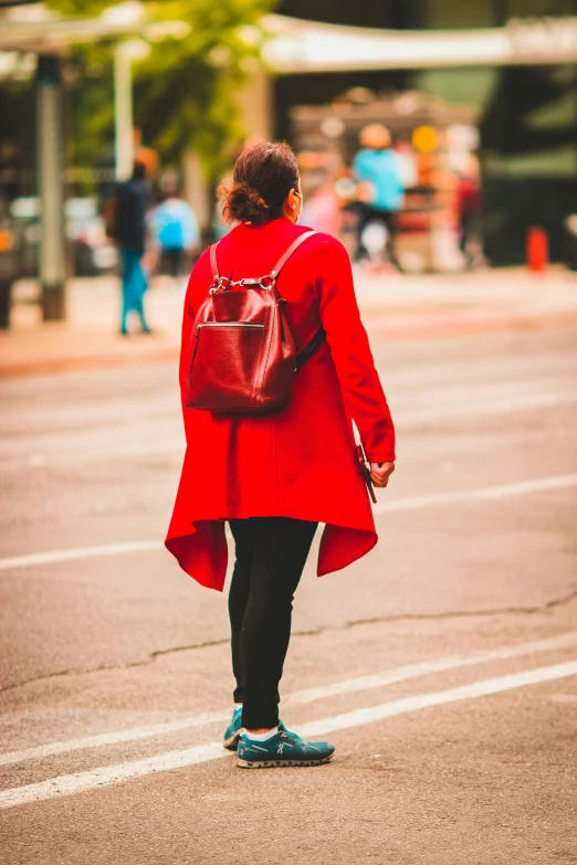 the woman is walking down the street in red