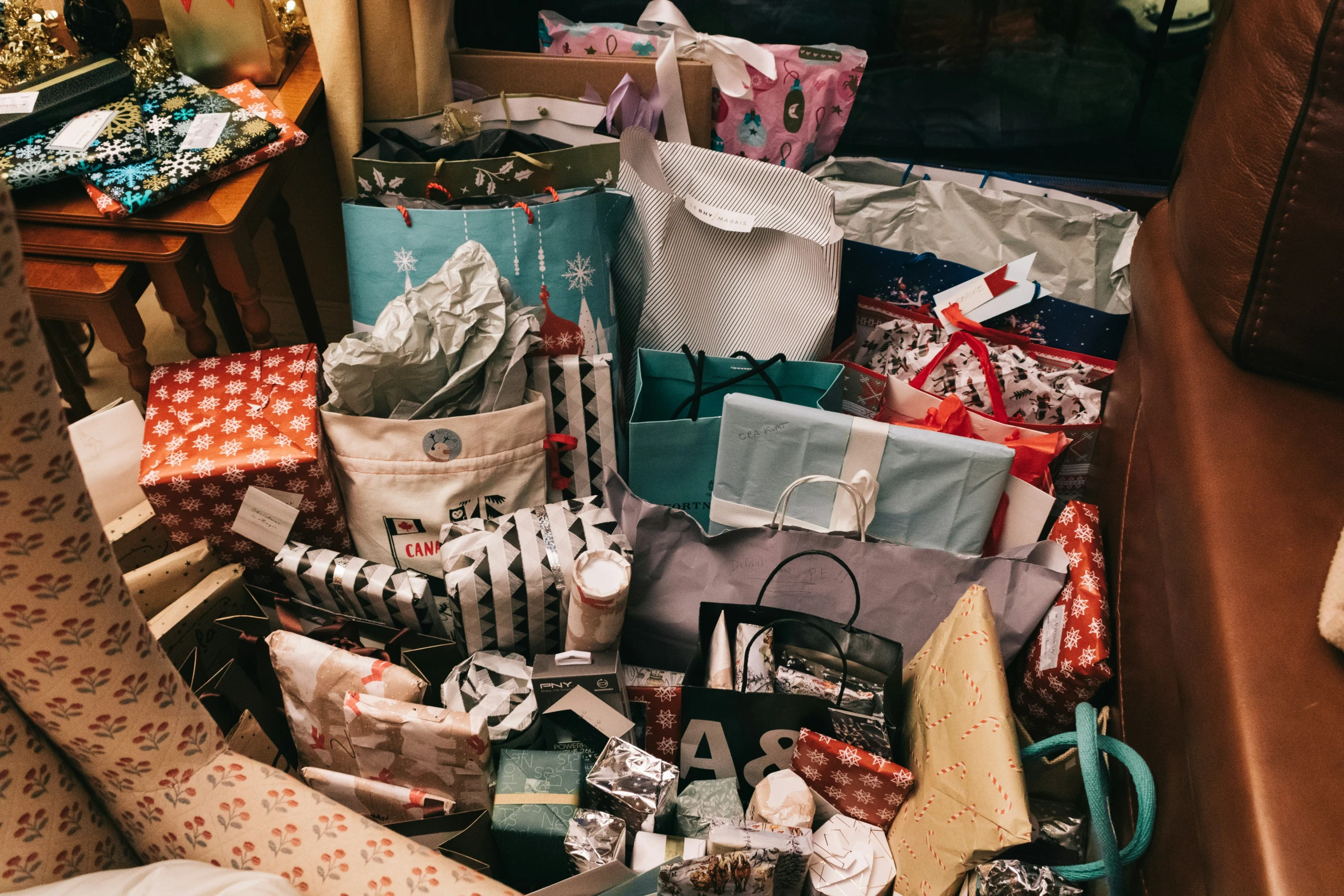 a pile of christmas presents with gift wrapping