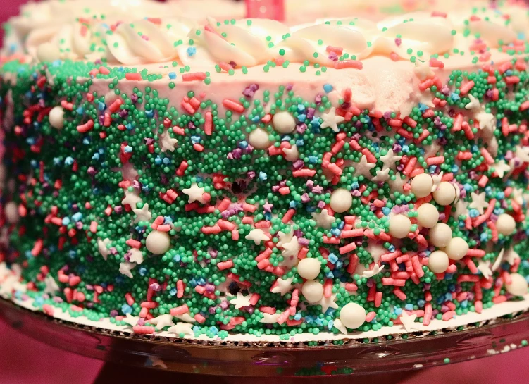 a green cake with sprinkles on it