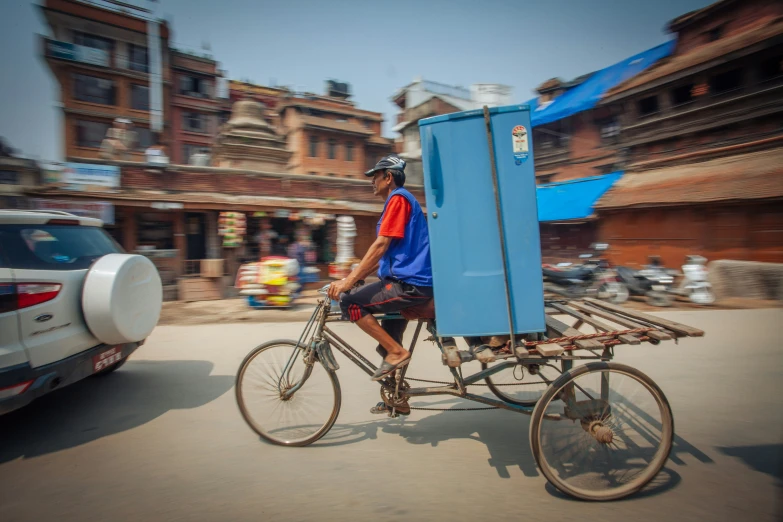 a man riding his bike carrying an unusual object