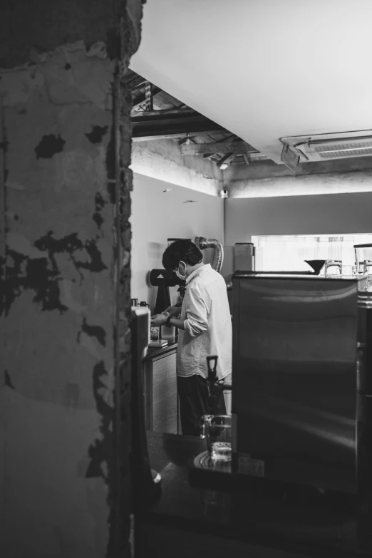 a man standing in a kitchen next to a sink