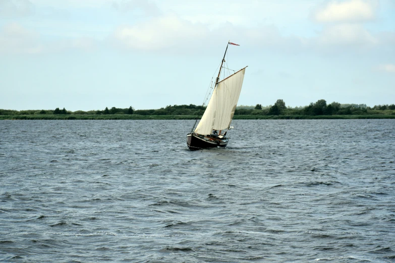 a boat out in the water sailing on calm blue waters