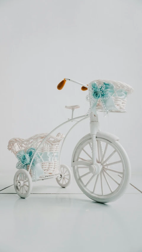 a small white bike has a basket full of flowers