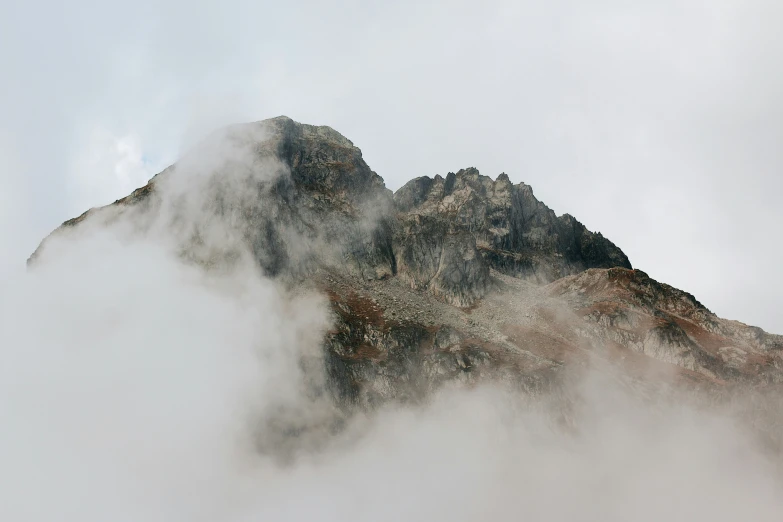 the view of an mountain peak rising through fog