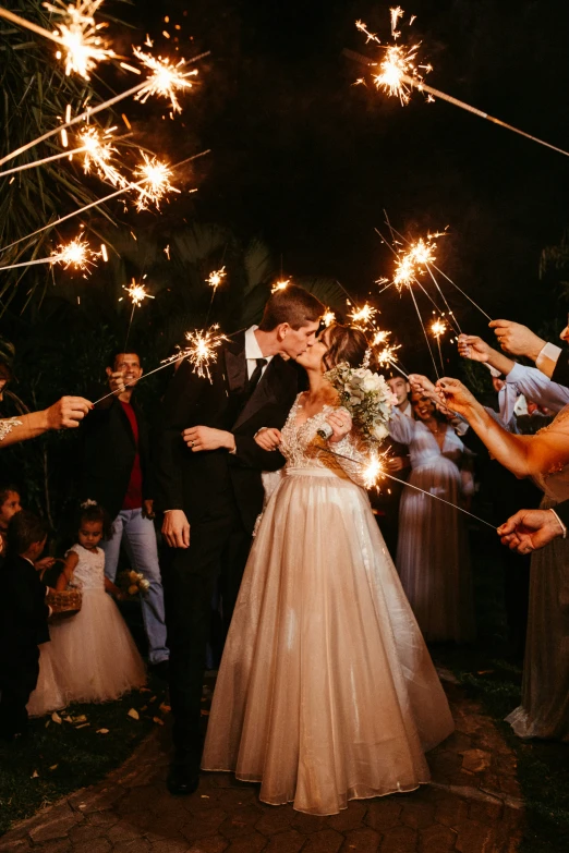 a newly wed couple is surrounded by people holding sparklers