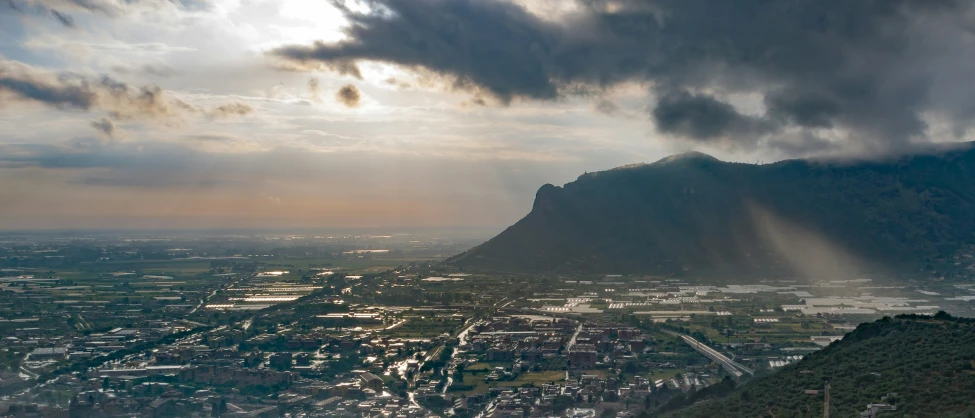 a bird - eye view of the city below, with storm clouds overhead