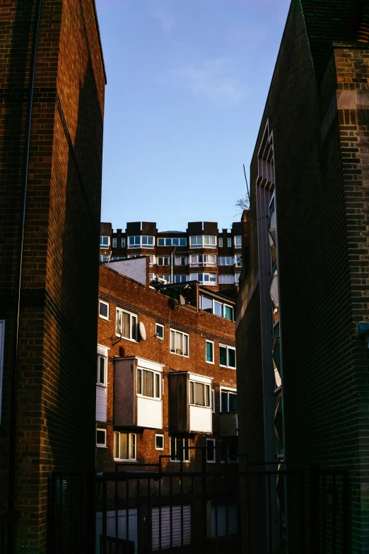 a gate is between two tall brick buildings