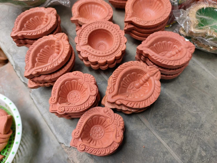 small round clay bowls with decorative carvings sitting on a counter