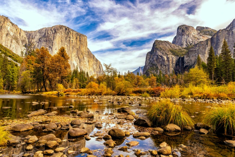 the view of a valley with a river running between tall mountains