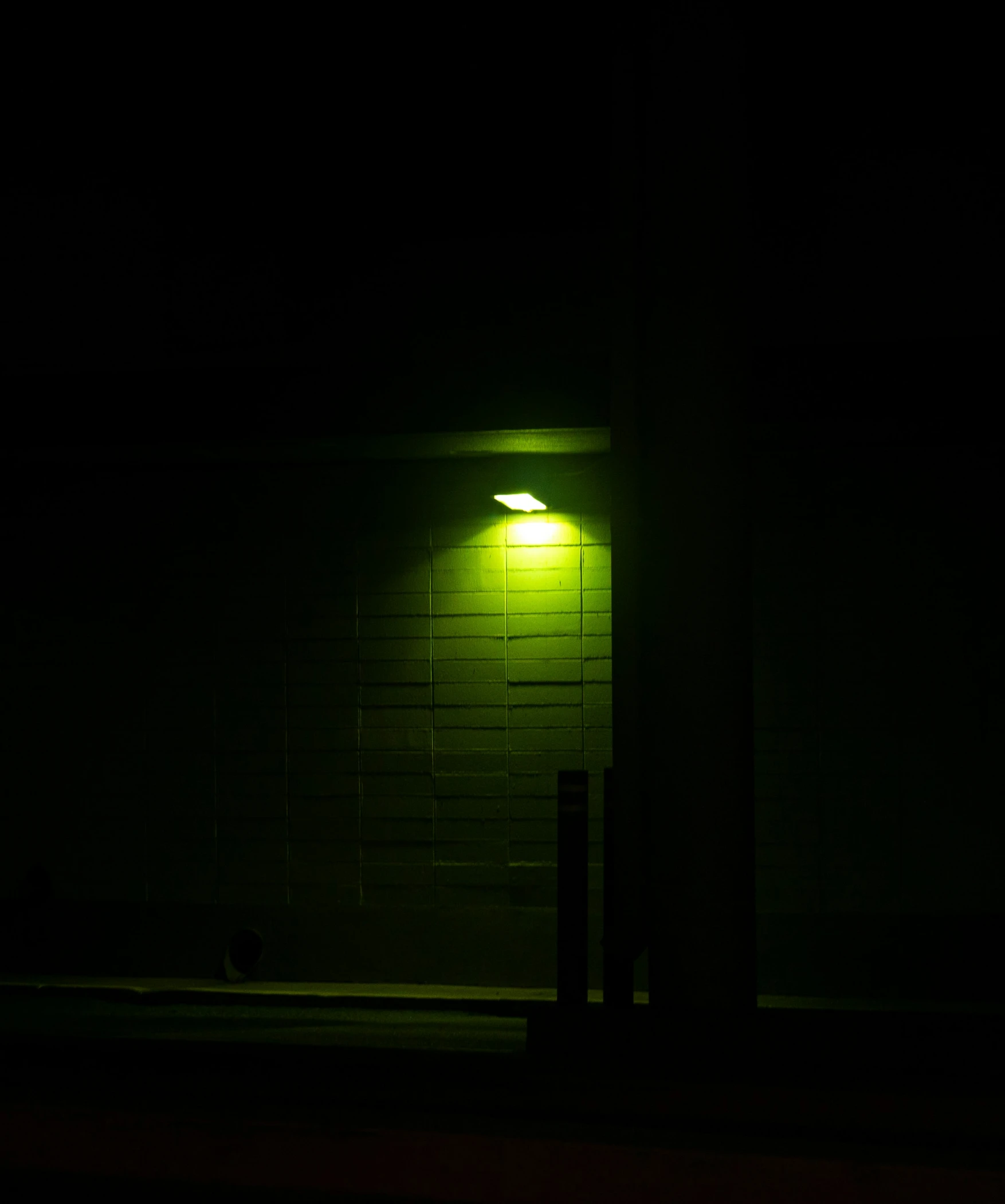 a streetlight glows on a brick building by the night