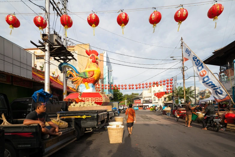 two people walking down a street next to many chinese decorations