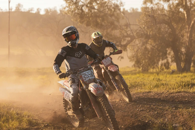 a group of dirt bikers traveling on top of dirt