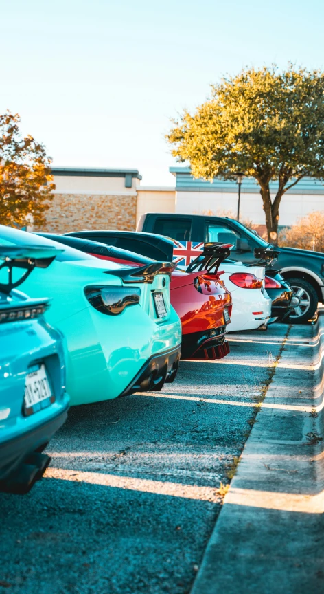 a parking lot filled with parked cars under a tree