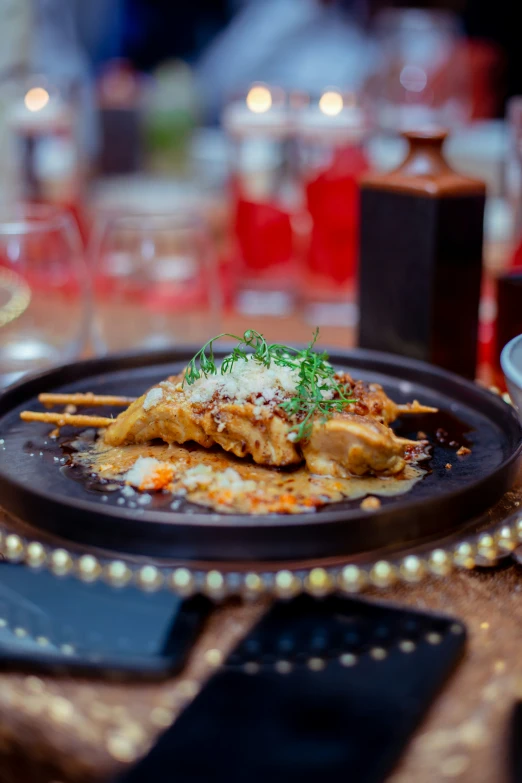 there is food on a black plate and garnished with green herbs