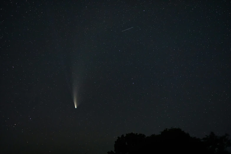 a bright comet is shining in the night sky