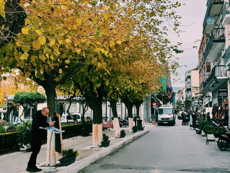 a street scene with cars, people and trees