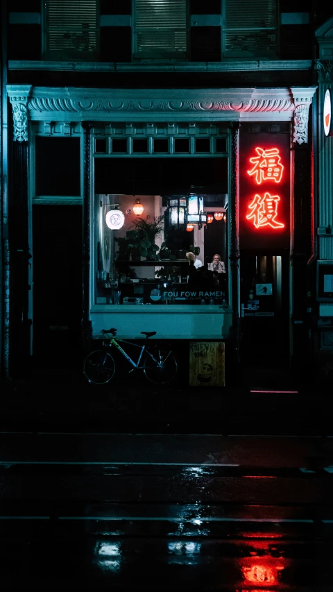the side of a business with neon lights in the dark
