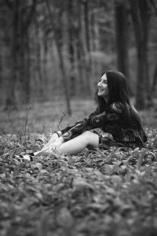 a beautiful woman laying in the grass in black and white