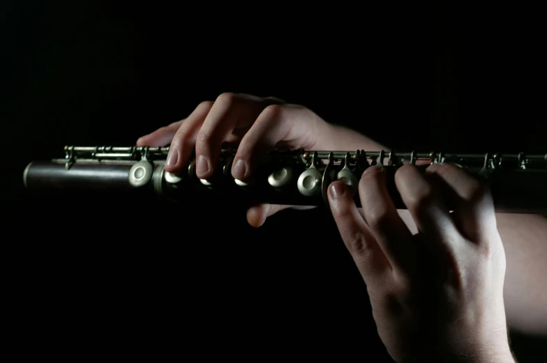 the hands of a person playing an flute