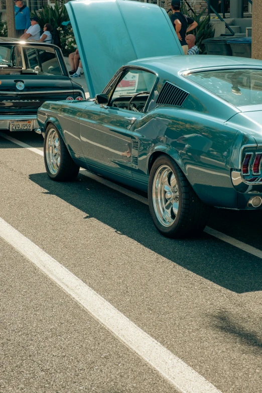 the rear end of a turquoise car is stopped in the street