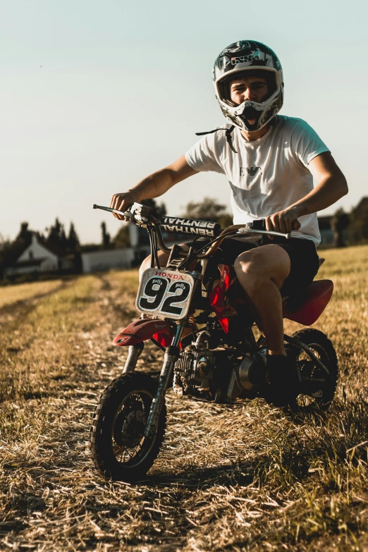 a man in helmet sitting on his dirt bike