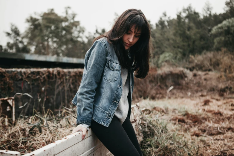 a girl in jeans standing in a field