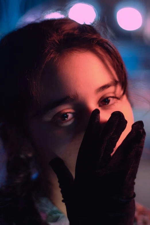 a woman holding her face and hands together to the camera