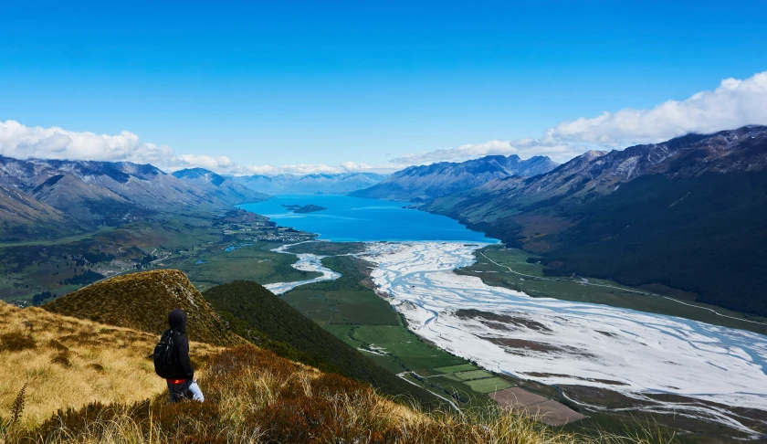 a woman on a hill overlooking a valley